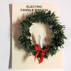 an electric candle wreath on top of a card