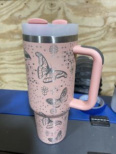 a pink coffee mug with butterflies and stars on it