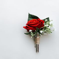 a red rose with white flowers and greenery in a silver vase on a white background