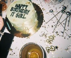 a birthday cake with the words happy birthday t girl written on it, surrounded by confetti and glasses