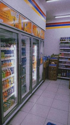 an empty grocery store with refrigerators full of drinks and beverages on the shelves in front of them