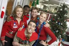 a group of people posing for a photo in front of a christmas tree with decorations on it