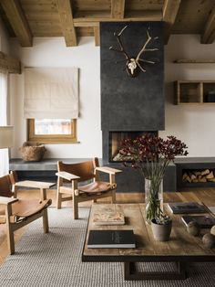 a living room filled with furniture and a large deer head mounted to the side of a wall