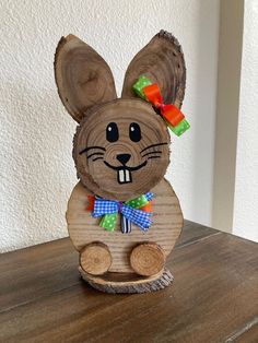 a wooden sculpture of a rabbit with a bow on it's head