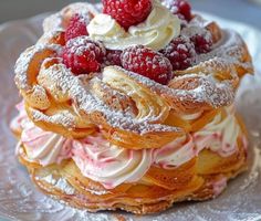 a cake covered in powdered sugar and raspberries on top of a plate