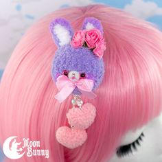 a close up of a pink and purple wig with a bunny earring on it