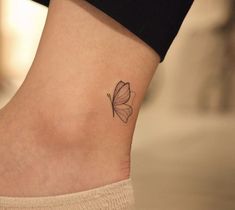 a small tattoo on the ankle of a woman's foot with a butterfly on it