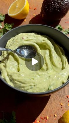 an avocado dip in a bowl with a spoon