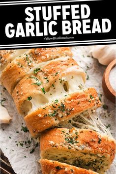 garlic bread sliced and sitting on top of a piece of parchment paper with text overlay