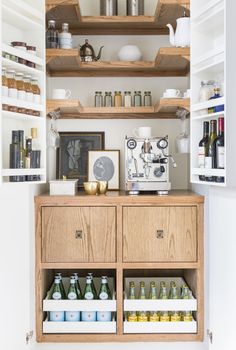 an open pantry with lots of bottles and containers on the shelves in front of it