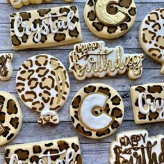 cookies decorated with leopard print and happy birthday written in white frosting on a wooden surface