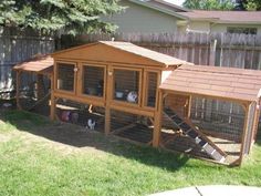 an outdoor chicken coop in the backyard with chickens inside and on it's roof