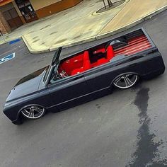 a black car with red seats parked in a parking lot