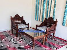 two wooden chairs sitting on top of a rug