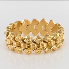 This is part of Chairish’s Fine Jewelry assortment.  Bracelet in 18 carat yellow gold, eagle head hallmark.  Composed of 17 scroll motifs, with a decoration of lines and golden beads, linked together.  The clasp is an 8 shaped ratchet with safety chain.  Internal Diameter: 5.5 cm, total length: 22.5 cm, width: 2.2 cm.  Total weight : 92.4 g approximately.  Authentic vintage bracelet - French work created in the 1940-1950s.  Our opinion : A magnificent and voluminous bracelet, a classic from the Gold Necklace Indian, Golden Beads, Gold Necklace Indian Bridal Jewelry, Gold Eagle, Eagle Head, Safety Chain, Vintage London, Vintage Bracelets, Gold Gold