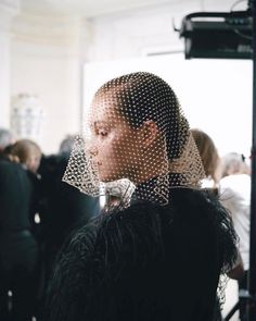 a woman with a veil on her head in front of a group of other people