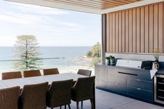 an outdoor kitchen and dining area overlooking the ocean