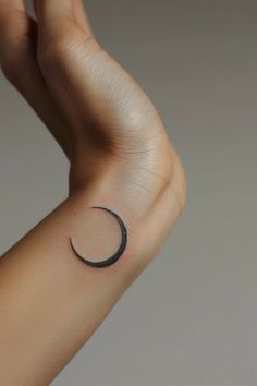 a woman's arm with a crescent tattoo on it