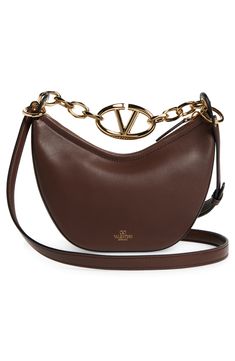 A gleaming chain centered with a VLOGO insignia spans the top of this hobo crafted from grained leather in a slouchy crescent silhouette. Top zip closure Chain top carry handle; removable, adjustable shoulder strap Leather Made in Italy Designer Handbags Elegant Brown Shoulder Bag With Metal Logo, Luxury Brown Shoulder Bag With Metal Logo, Luxury Brown Bag With Metal Logo, Chain Top, Hobo Bag, Valentino Garavani, Designer Handbags, Crescent, Top Handle