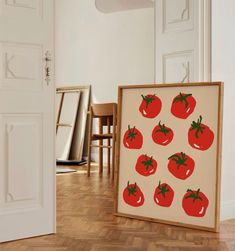 there is a painting with tomatoes on it next to the door and chairs in the room