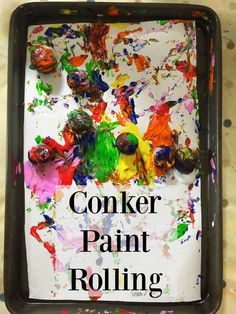 a black tray filled with colorful paint and the words conker paint rolling on it