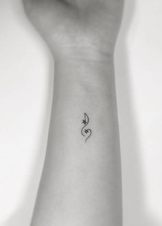 a person's arm with a small musical note tattoo on the left side of their wrist