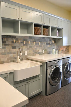 a washer and dryer in a room with cabinets on either side of the sink