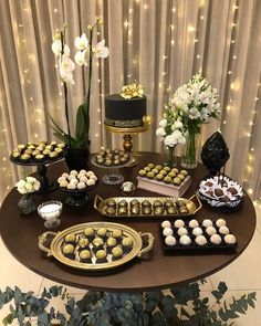 a table topped with lots of desserts next to a cake and flower vase filled with flowers