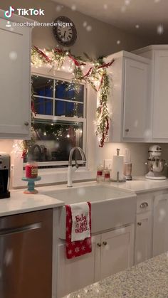 a kitchen decorated for christmas with lights and garland on the window sill above the sink