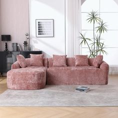 a living room filled with furniture and a large potted plant on top of a rug