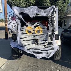 a jeep decorated for halloween with a skeleton and spider web on the front door window