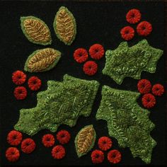 some red flowers and green leaves on a black surface with brown trimmings to the edges