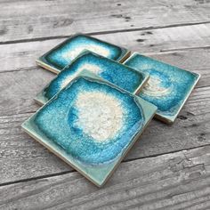 three blue and white plates sitting on top of a wooden table