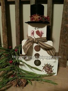 a snowman made out of wood sitting on top of a wooden chair next to pine cones