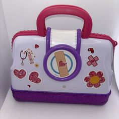 a purple and white suitcase with stickers on the front is sitting on a shelf