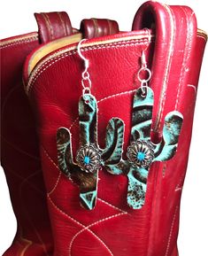 a pair of cowboy boots with earrings hanging from them