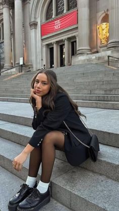 a woman is sitting on the steps talking on her cell phone