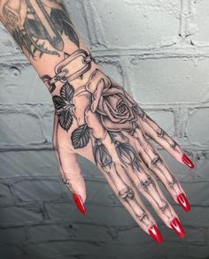 a woman's hand with tattoos and roses on it