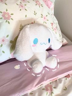 an elephant stuffed animal sitting on top of a bed next to pillows and pillow cases