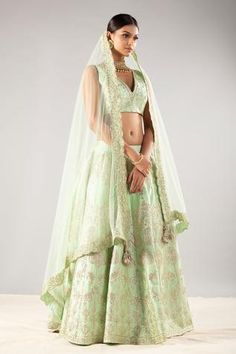 Mint green blouse with all-over embroidered. Comes with zari and dori work lehenga and a net scallop dupatta with tassel detailing. 
Component: 3
Pattern: Embroidered 
Type Of Work: Zari, gota and dori 
Neckline: V Neck 
Sleeve Type: Sleeveless 
Fabric: Silk Tafetta, Net
Color: Green 
Other Details: 
Tassel detailing on dupatta edges
Occasion: Bride, Destination Wedding, Reception  - Aza Fashions V Neck Lehenga, Dupatta Embroidery, Dori Embroidery, Mint Green Blouses, Mint Fabric, Embroidery Hand, Indian Bridal Makeup, Pakistani Bridal Wear, Net Dupatta