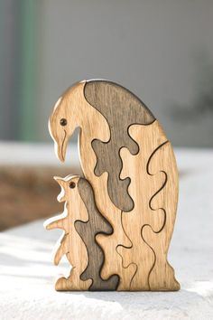 a wooden sculpture of a sea horse and her foal is shown on a white surface