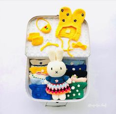 an open suitcase filled with knitted items like hats, mittens and sweaters