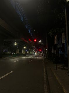 an empty city street at night with traffic lights