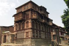 an old building with many windows and balconies on the top floor is surrounded by stone steps