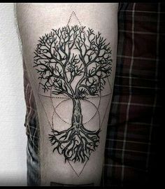 a man's leg with a tree tattoo on the side of his arm,