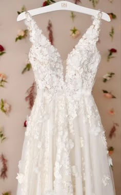 a white wedding dress hanging on a hanger