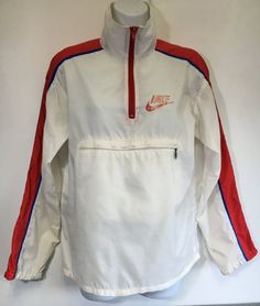 Here's a classic vintage Nike windbreaker! A large Nike logo is printed on back. The red, white, and blue color combo is perfect! There is a Nike tag inside the large front zipper pocket with the added bonus of being able to stuff the whole jacket into the pocket, zip it up, and peace out with your pouch! It shows some general wear---small marks, a hole at the pit seam, graphic wear, etc. But overall the fabric is in good condition and it has tons of fun left in it! Check out other sensational v Vintage Windbreaker For Fall Sports, Vintage Nylon Windbreaker For Streetwear, Retro Spring Windbreaker For Outdoor, Retro Track Jacket For Spring Streetwear, Retro Spring Track Jacket For Streetwear, Retro Nylon Track Jacket For Outdoor, Sporty Streetwear Windbreaker With Ykk Zipper, Sporty Windbreaker With Ykk Zipper For Streetwear, Retro Hooded Track Jacket For Sports