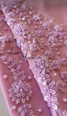 a pink dress with flowers and pearls on it