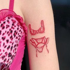 a woman's arm with tattoos on it and two bras in red ink