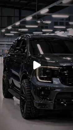 the front end of a black truck parked in a garage